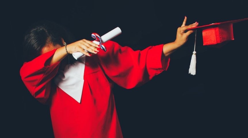 A student dabbing after receiving her diploma.